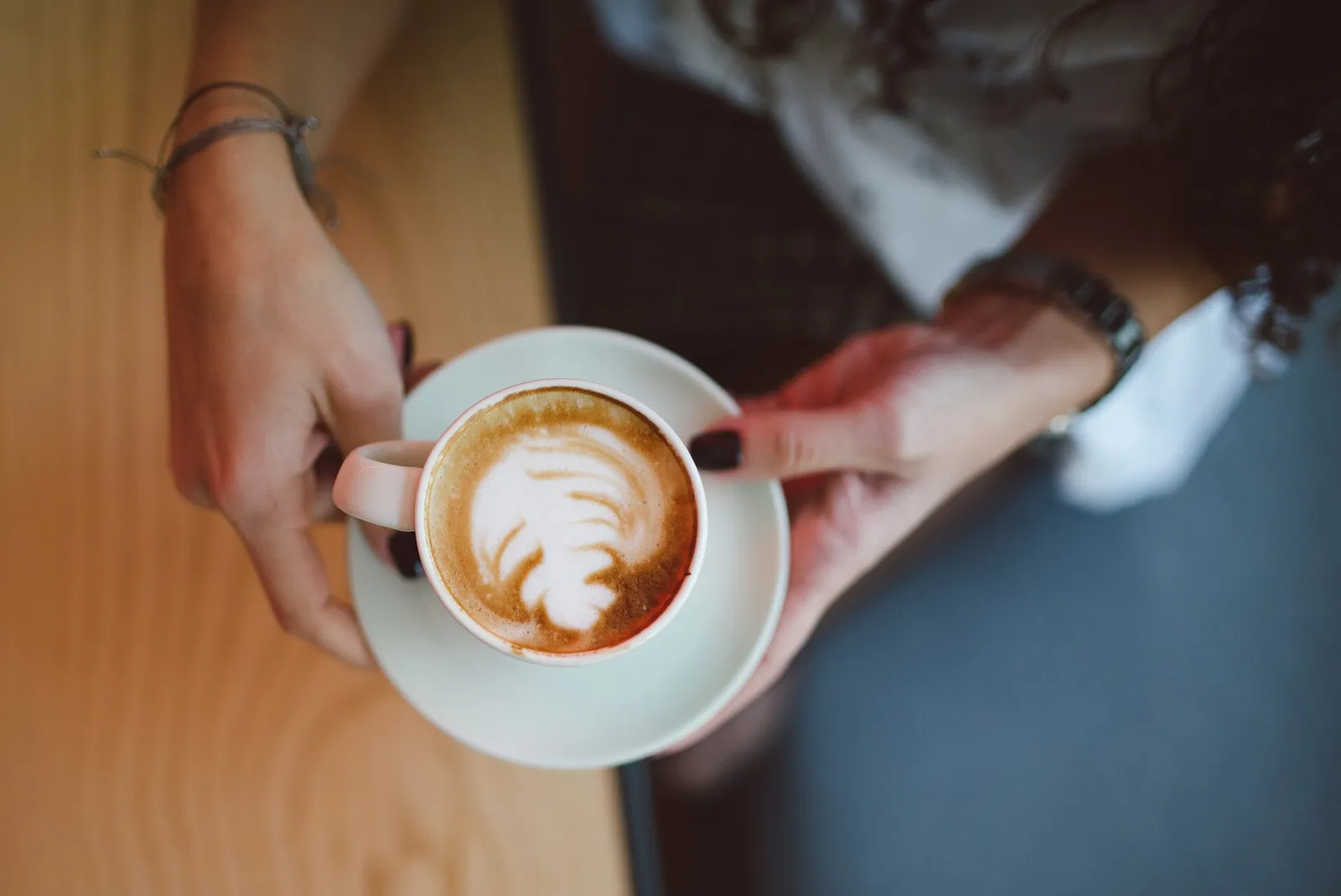 A cappuccino with latte art on a cafe table. The photo was not taken in Duluth.