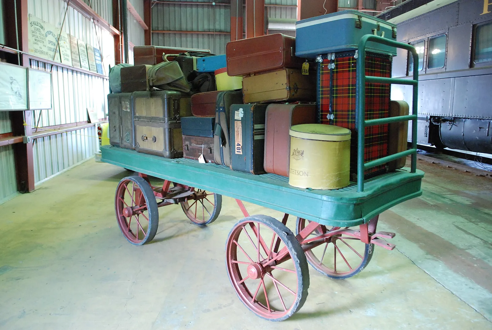 A vintage baggage cart piled with old suitcases inside the Southeastern Railway Museum in Duluth