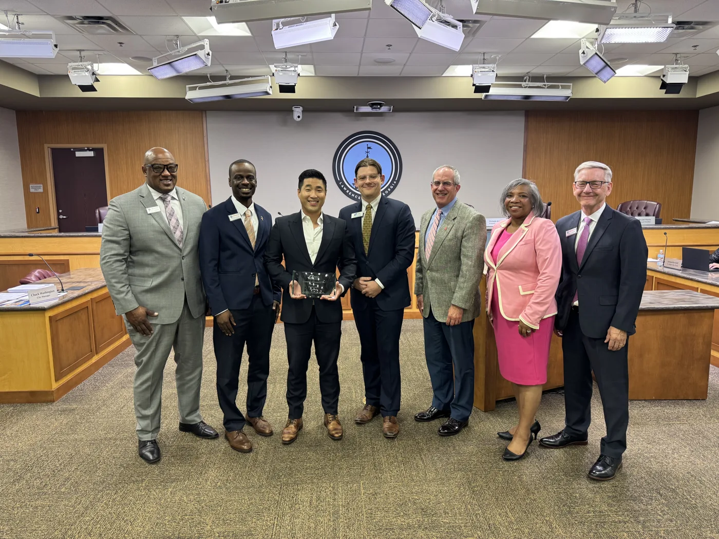 Rep. Sam Park, center, holds the Champion of Georgia's Cities Award with Lawrenceville city leaders and Noah Roenitz of the Georgia Municipal Association in the Lawrenceville council chamber.